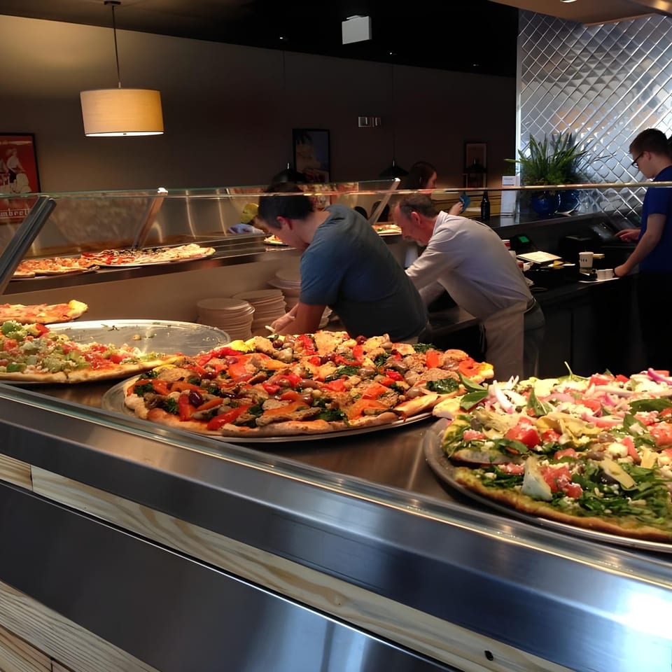 Christian's Pizza employees preparing and serving various pizzas with fresh toppings in a brightly lit restaurant.